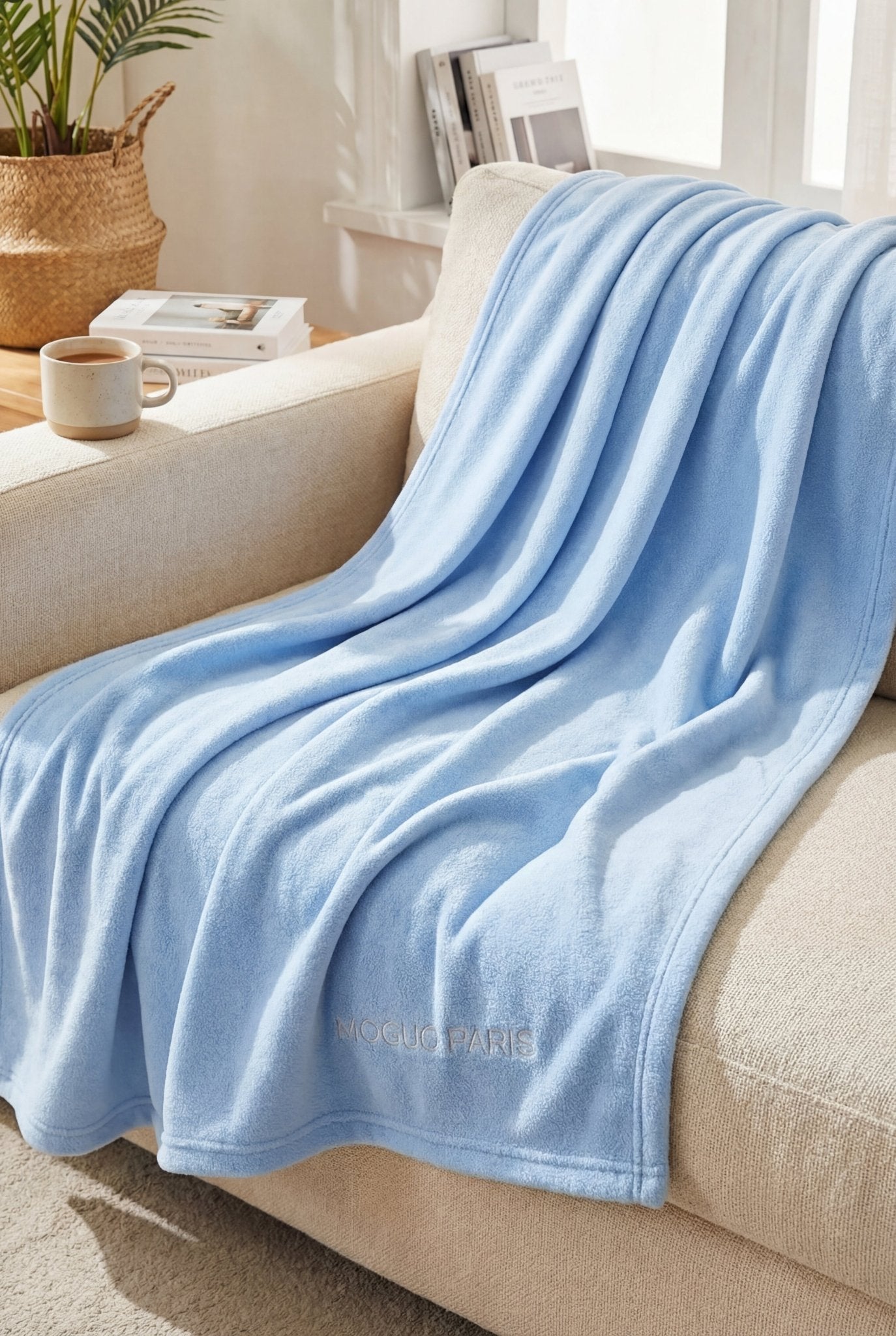 Mannequin femme profitant du confort d'un grand plaid moelleux bleu ciel sur un canapé.