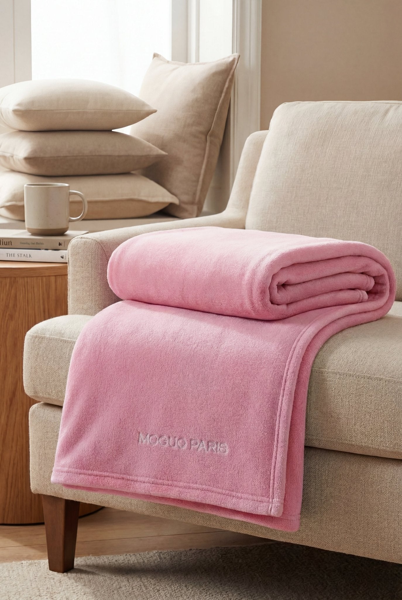 Détail de la texture douce et moelleuse du plaid en coraline rose Moguo Paris.