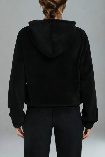 Femme se relaxant avec le sweat Signature noir en Coraline ultra-douce.